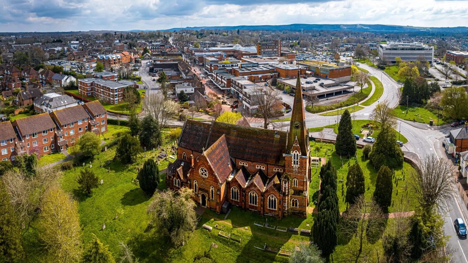 Aerial view of St John's Church and Burgess Hill town centre, with the South Downs on the horizon