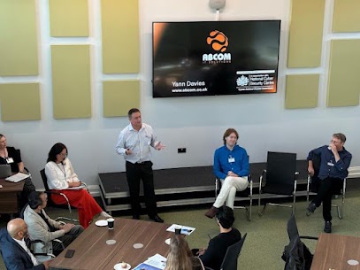 Yann Davies of ABCOM speaking to local business owners at the Mid Sussex District Council Exploring the Future of AI event, with the ABCOM and NCSC slide on screen